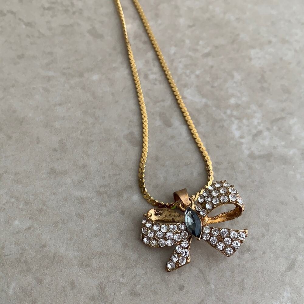 Gold tone bow pendant necklace with rhinestones & smoky blue glass middle stone